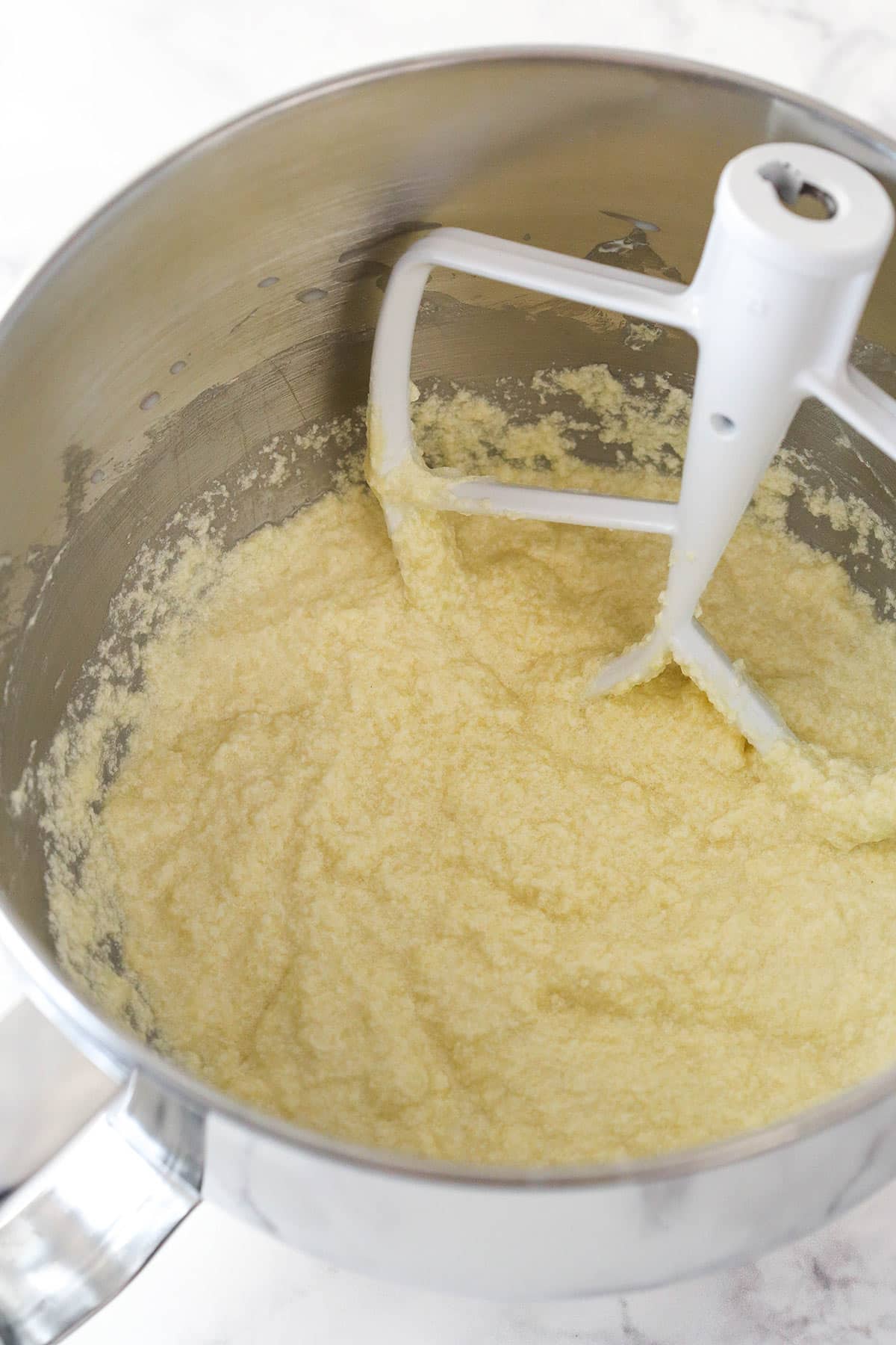 Overhead view of dry ingredients and milk combined to batter in a large mixing bowl