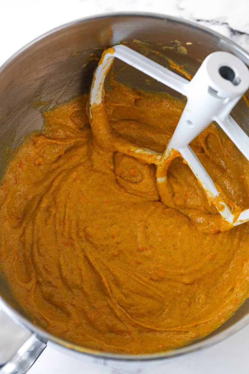 Mixing dry ingredients and carrot puree into carrot cake batter.