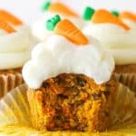 A carrot cake cupcake with a bite taken out of it.