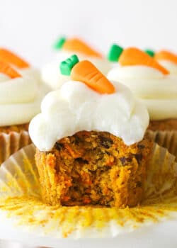 A carrot cake cupcake with a bite taken out of it.