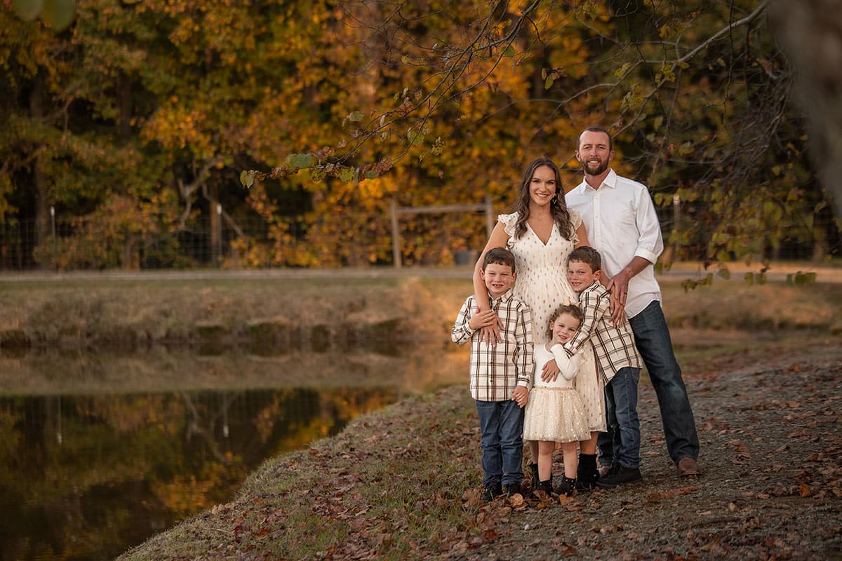 whole family standing by pond