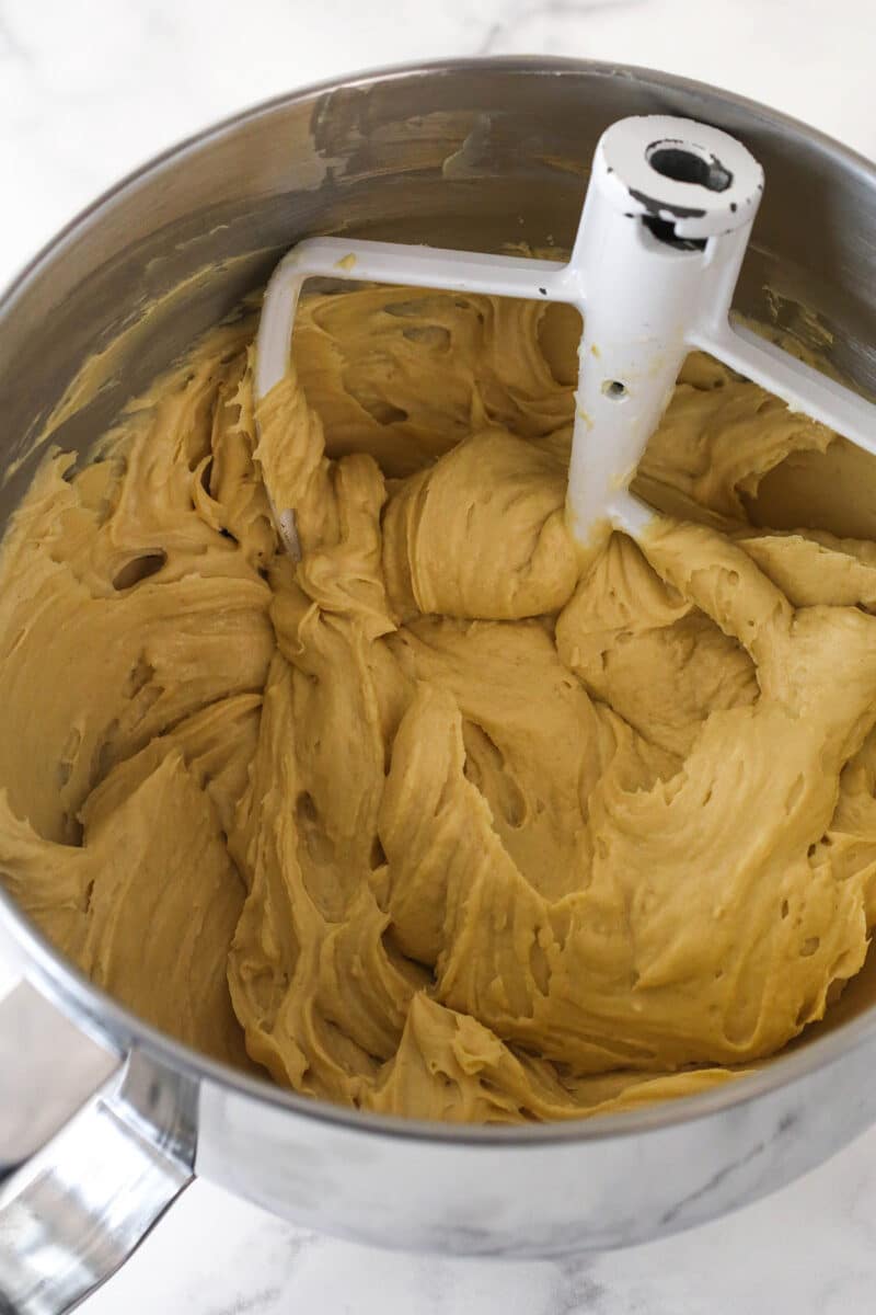 Mixing sour cream, peanut butter, and vanilla extract into cheesecake batter.