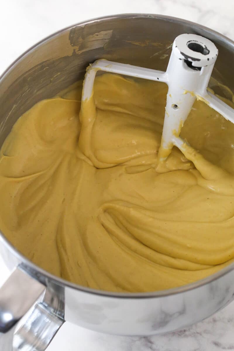 Mixing eggs into peanut butter cheesecake batter.
