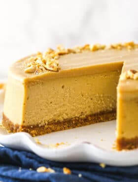 Peanut butter cheesecake with a slice taken out of it.
