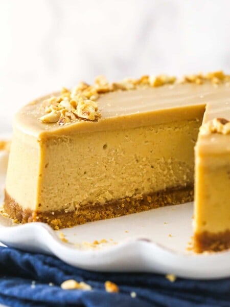 Peanut butter cheesecake with a slice taken out of it.