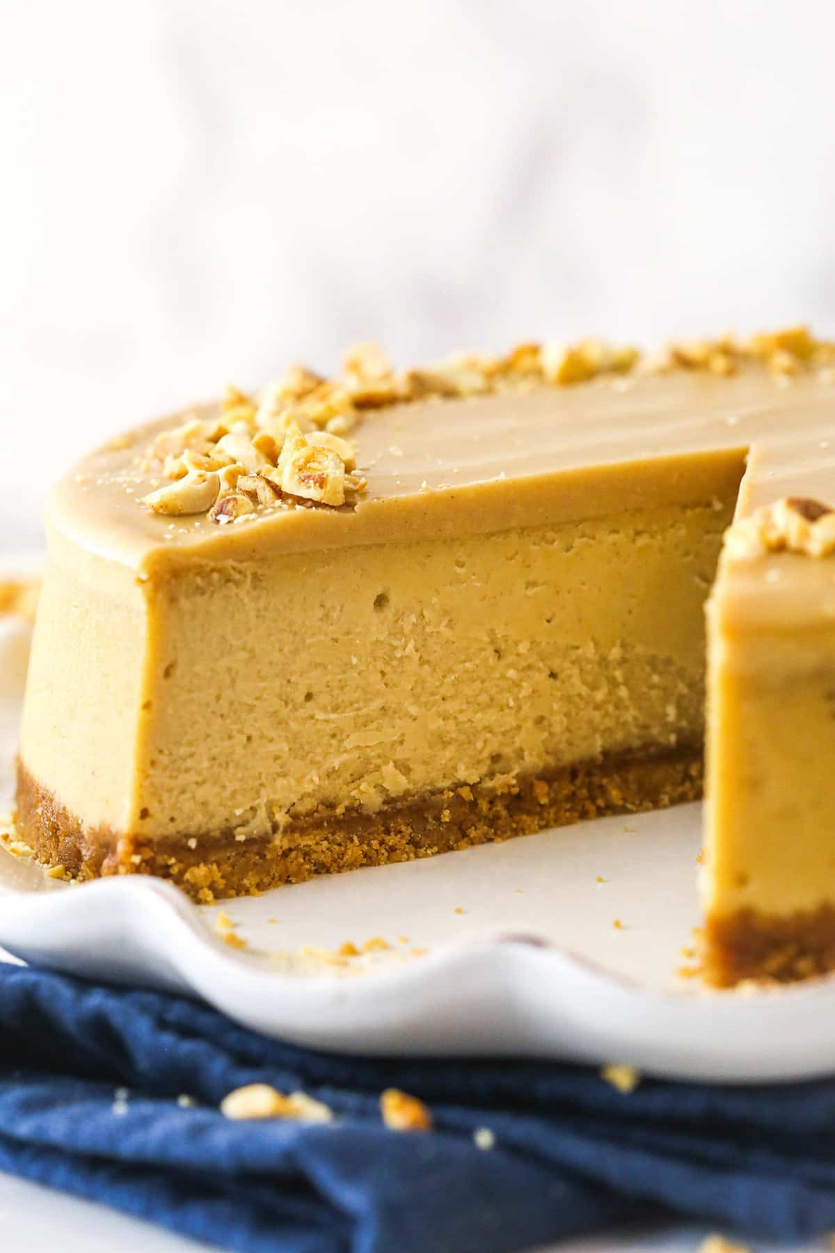 Peanut butter cheesecake with a slice taken out of it.