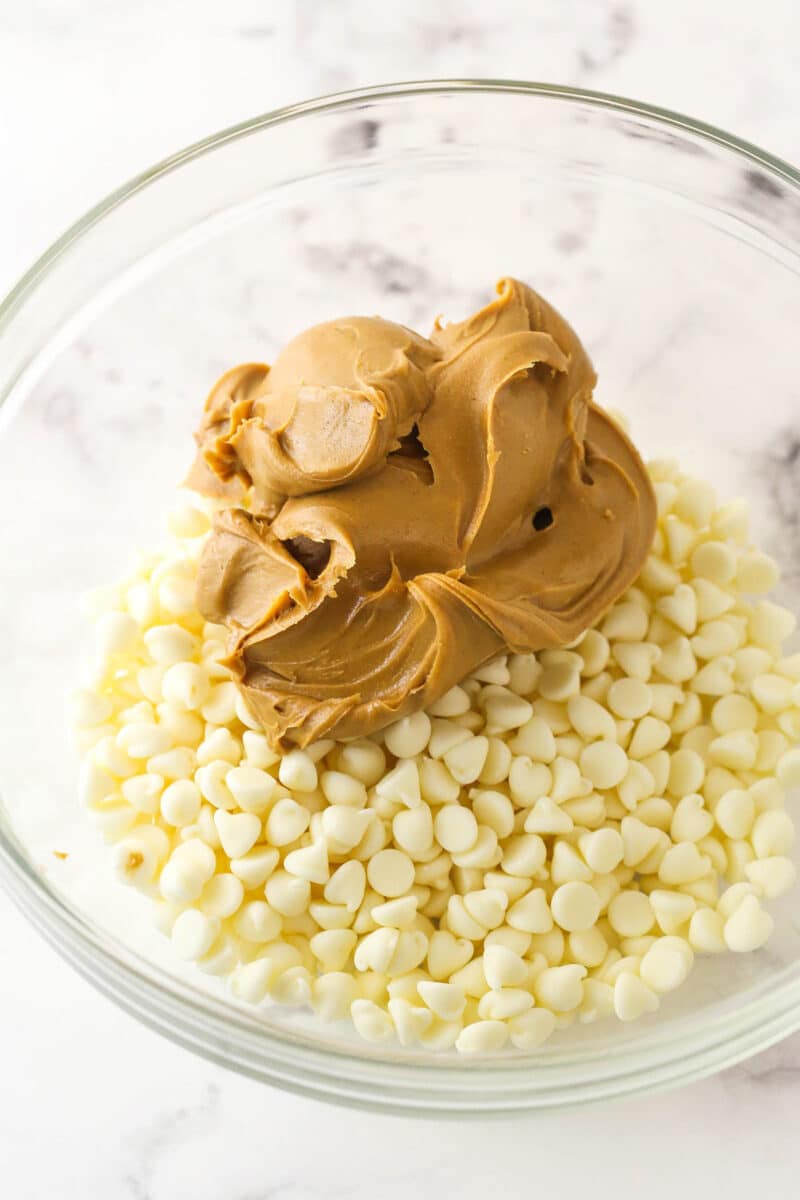 Adding peanut butter and white chocolate chips in a mixing bowl.