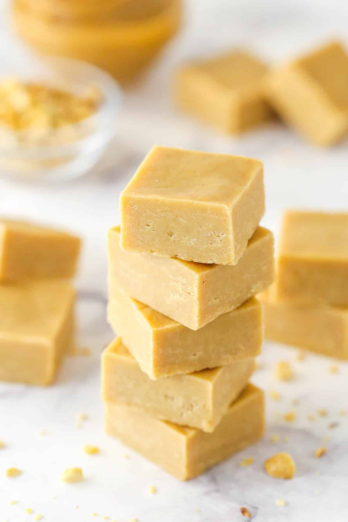 A stack of peanut butter fudge pieces surrounded by more squares of peanut butter fudge.