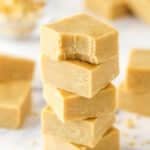 A stack pf peanut butter fudge pieces. The top piece has a bite taken out of it.