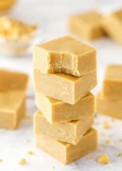 A stack pf peanut butter fudge pieces. The top piece has a bite taken out of it.