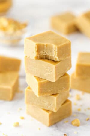A stack pf peanut butter fudge pieces. The top piece has a bite taken out of it.