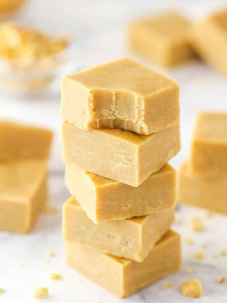 A stack pf peanut butter fudge pieces. The top piece has a bite taken out of it.