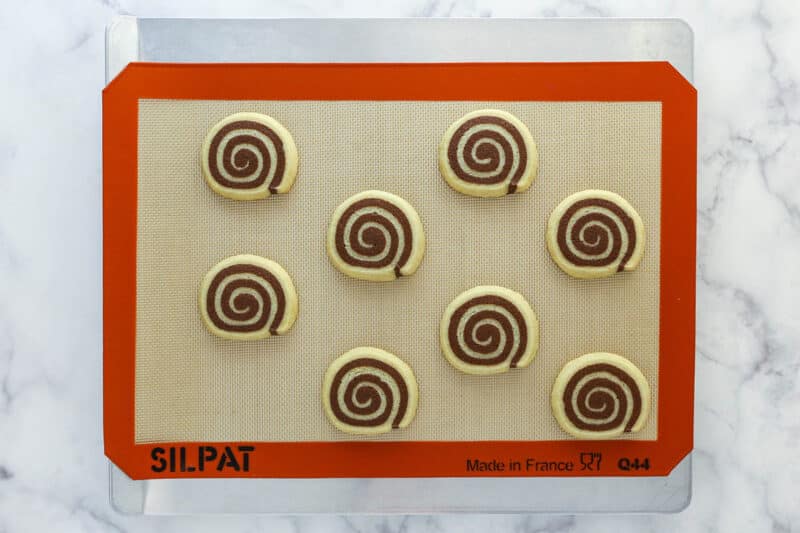 Pinwheel cookies on a silicon baking mat.