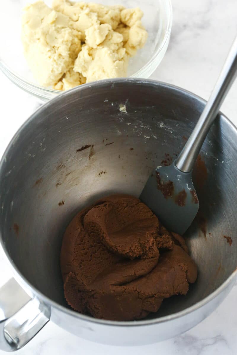 Mixing cocoa powder and melted chocolate into vanilla cookie dough to make chocolate cookie dough.