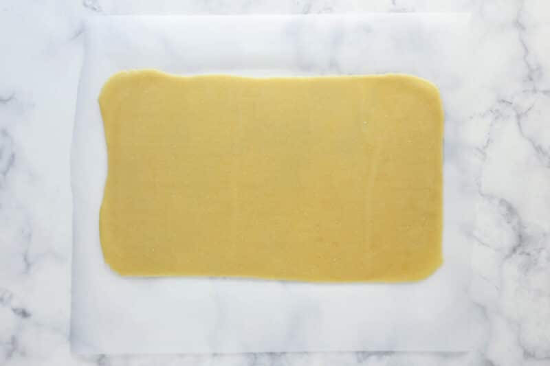 A rectangle of vanilla cookie dough on parchment paper.