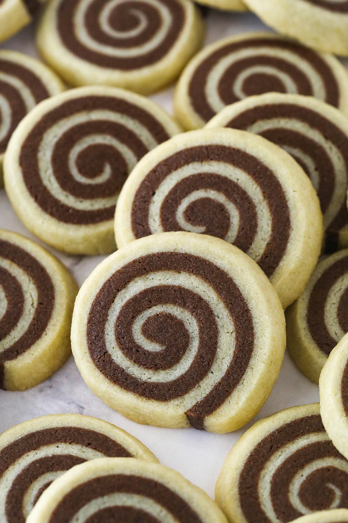 Closeup of pinwheel cookies spread over a work surface.
