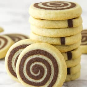 A stack of pinwheel cookies with two cookies leaning against it.