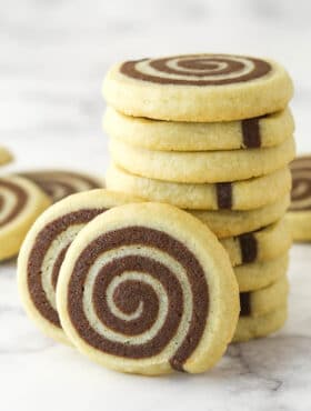 A stack of pinwheel cookies with two cookies leaning against it.