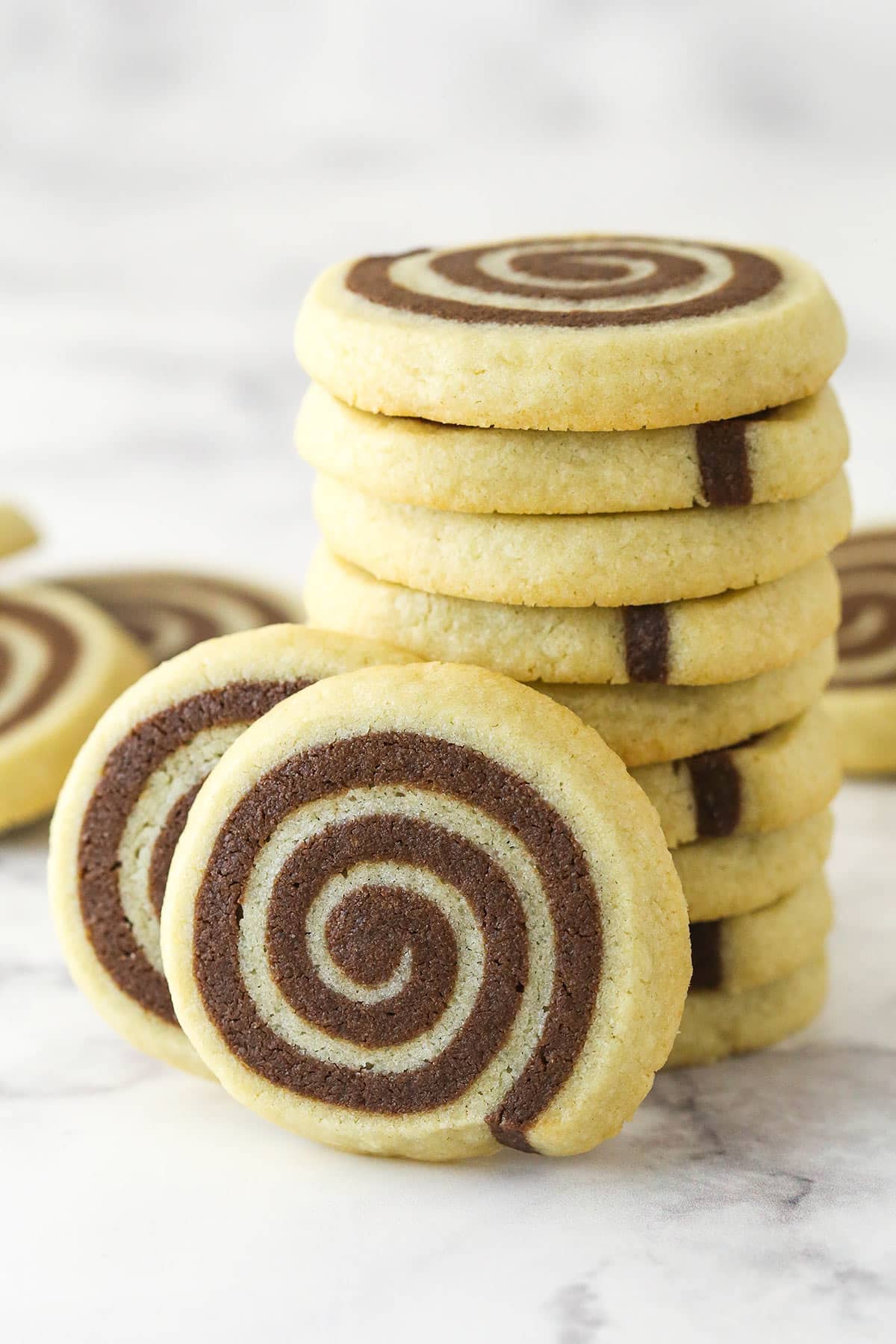 A stack of pinwheel cookies with two cookies leaning against it.