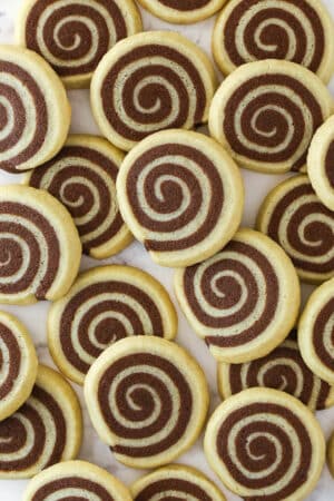 Overhead image of pinwheel cookies spread over a work surface.
