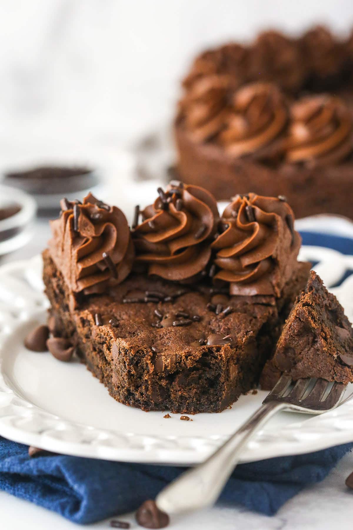 A fork taking a bite out of a slice of chocolate cookie cake.