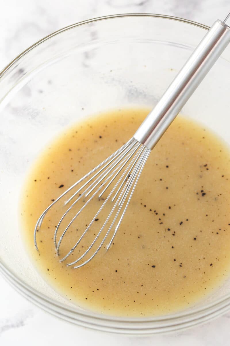 Whisking together vegetable oil, milk, sugar, espresso powder, vanilla extract, and salt for brownie batter.