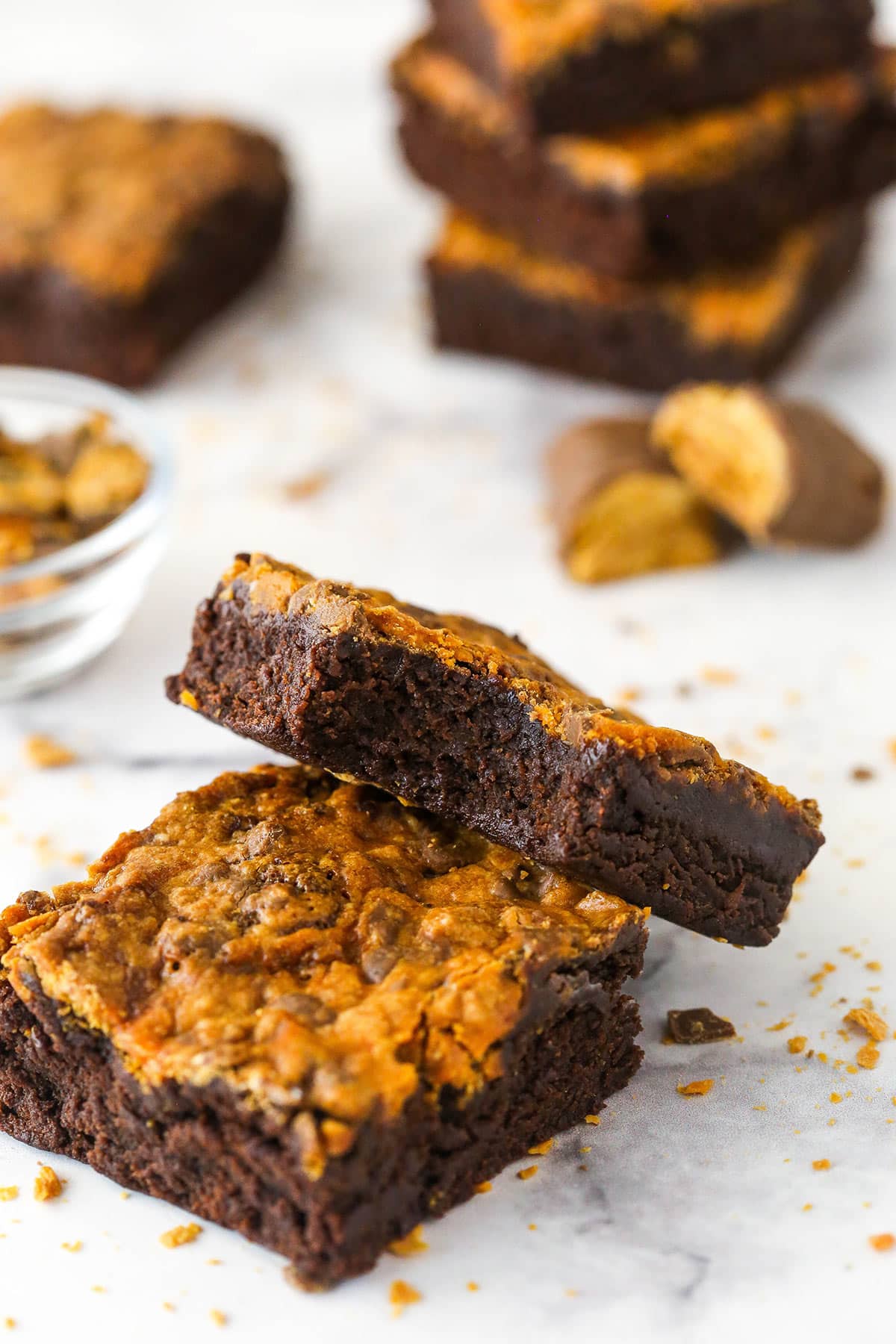 A butterfinger brownie with a bite taken out of it leaning on another butterfinger brownie.