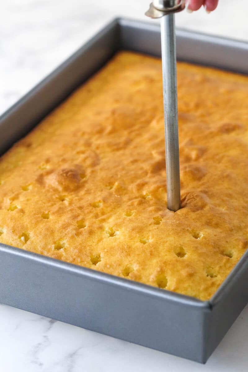 Poking holes in yellow cake.