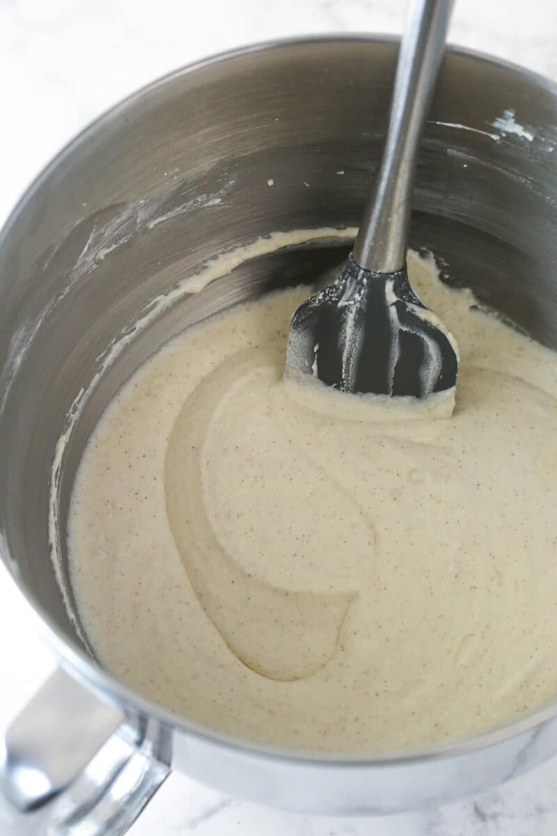 Stirring powdered sugar and cinnamon into a mixture of ricotta cheese, mascarpone cheese, and vanilla extract.