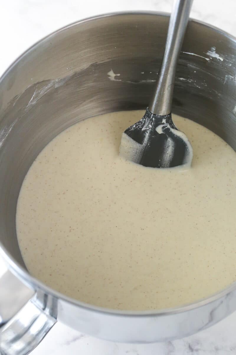 Stirring sweetened condensed milk into cannoli filling topping for poke cake.