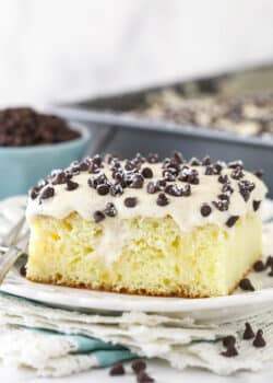 A slice of cannoli poke cake served on a plate.