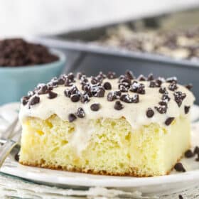 A slice of cannoli poke cake served on a plate.