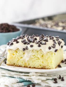 A slice of cannoli poke cake served on a plate.