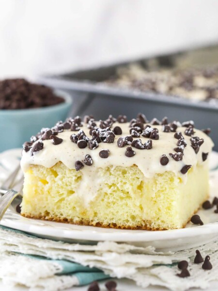 A slice of cannoli poke cake served on a plate.