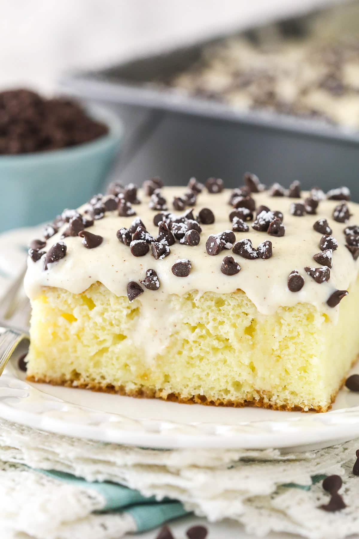 Closeup of a slice of cannoli poke cake served on a plate.