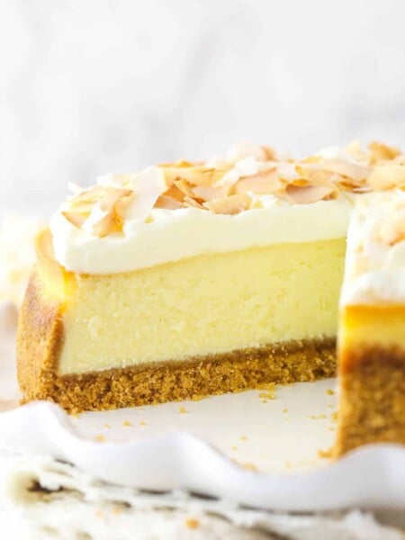 Coconut cheesecake with a slice taken out of it.