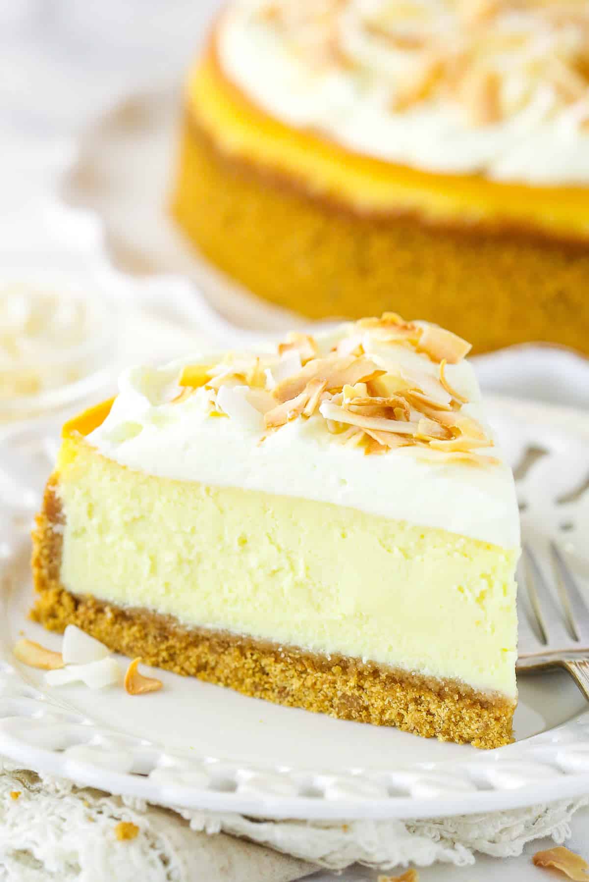 A slice of coconut cheesecake on a plate with a fork.