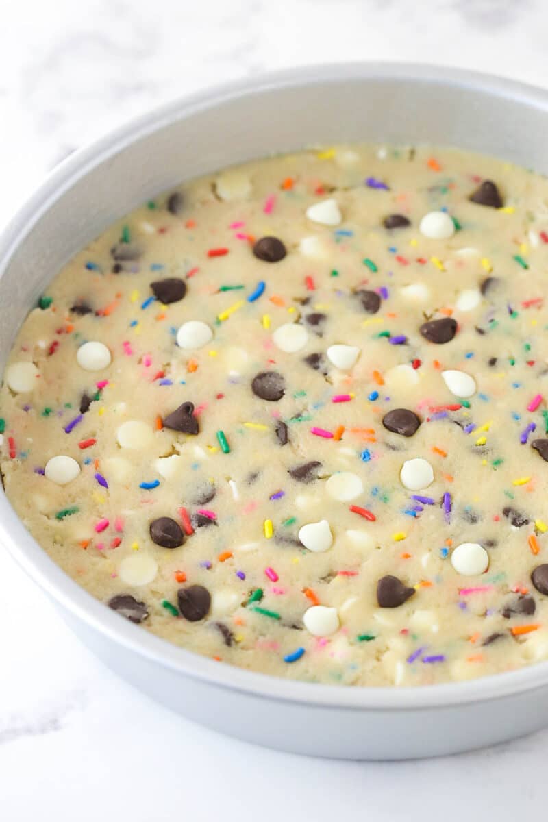 Funfetti cookie cake dough pressed into a cake pan.