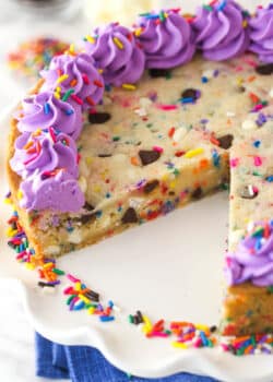 Overhead image of Funfetti cookie cake with a slice taken out of it.