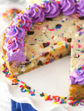 Overhead image of Funfetti cookie cake with a slice taken out of it.