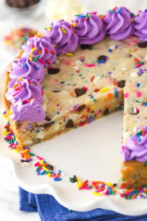 Overhead image of Funfetti cookie cake with a slice taken out of it.