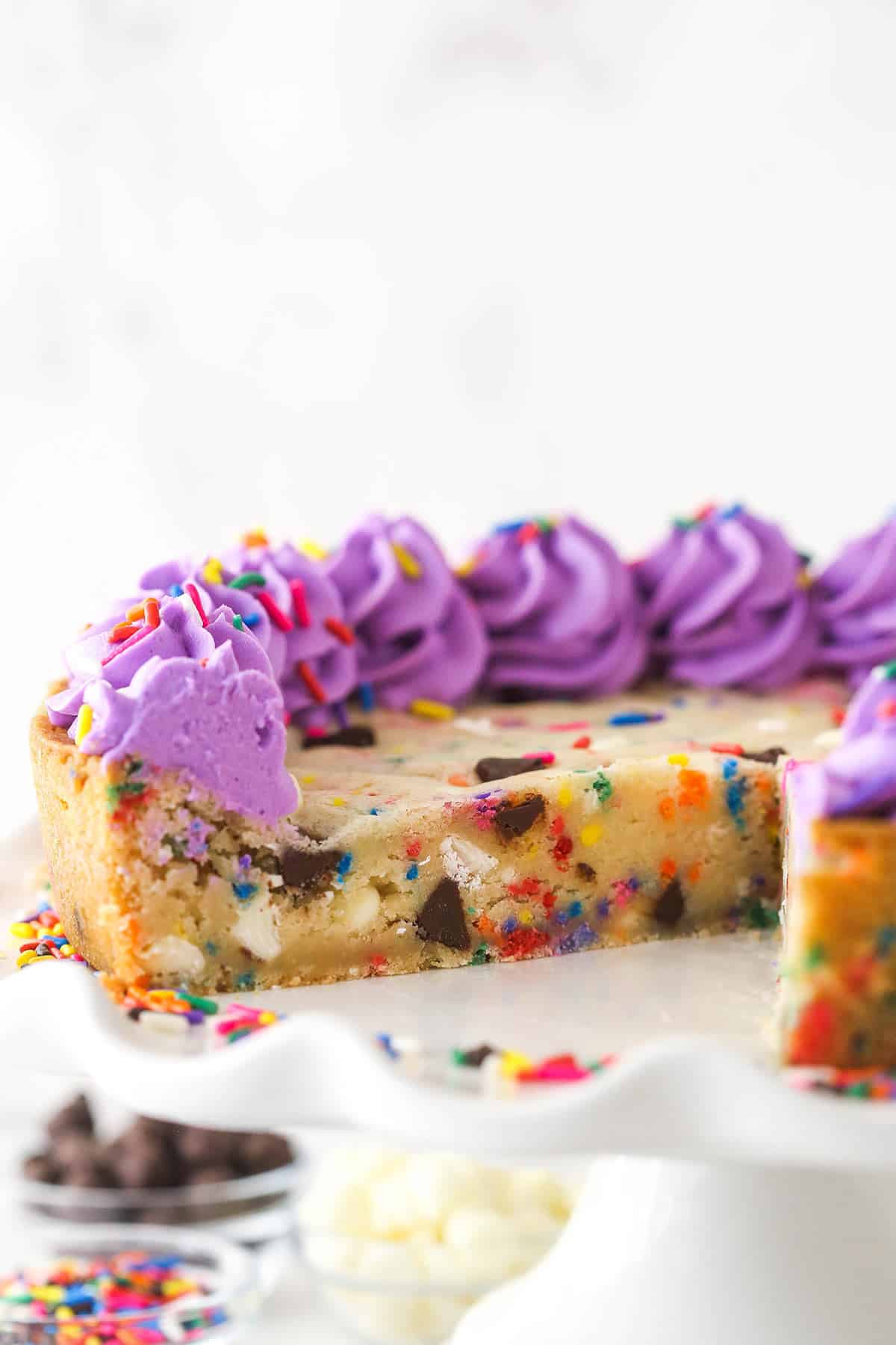 Funfetti cookie cake with a slice taken out of it.