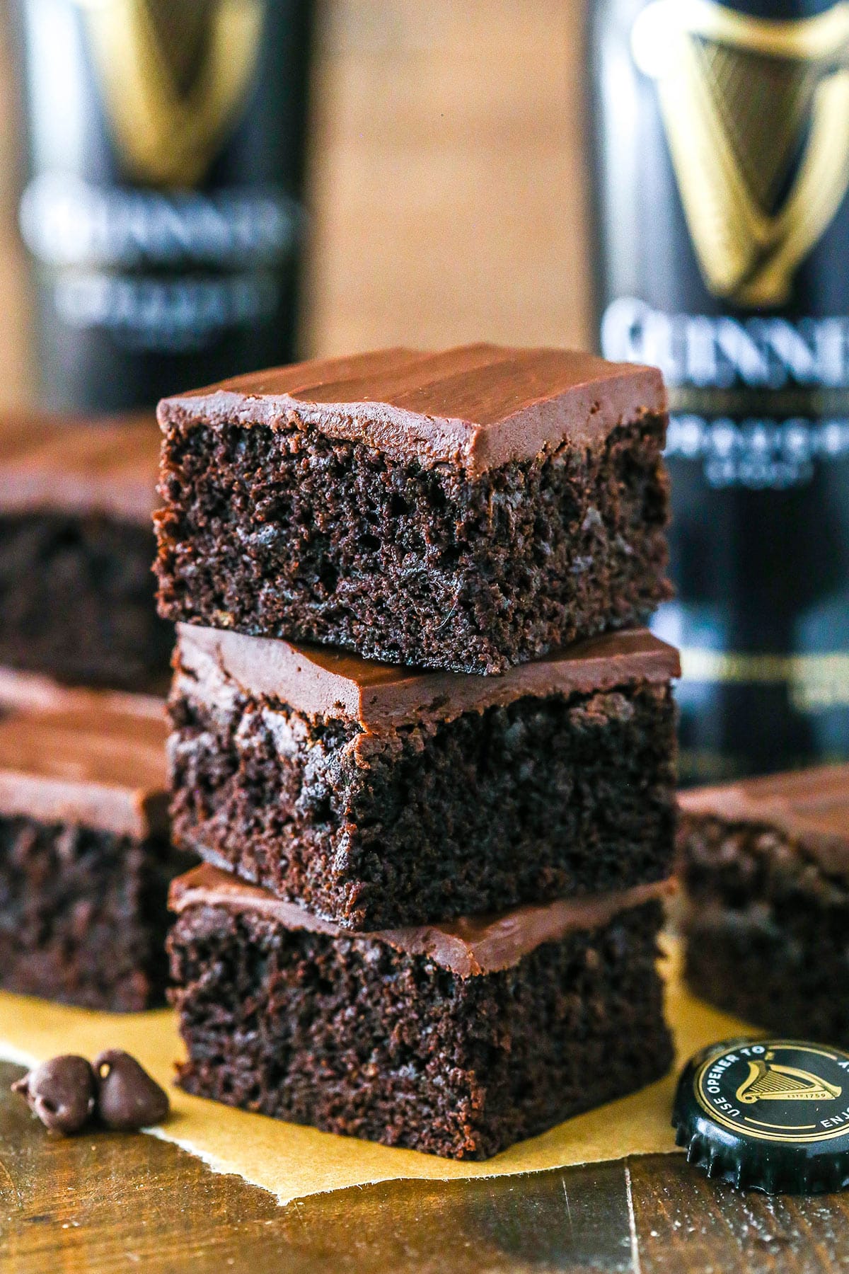 Moist Guinness brownies are somewhere between cakey and fudgy with a boozy kick and they're topped with a rich Guinness chocolate ganache. A stack of three Guinness brownies.