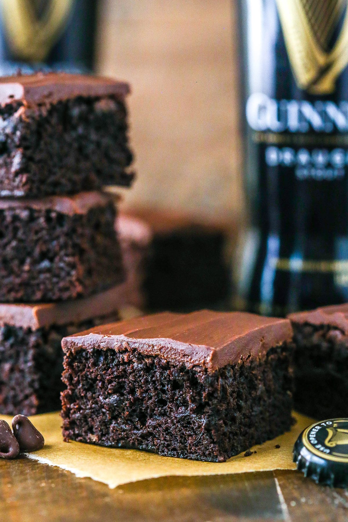 A Guinness brownie of a napkin with a stack of three Guinness brownies in the background.