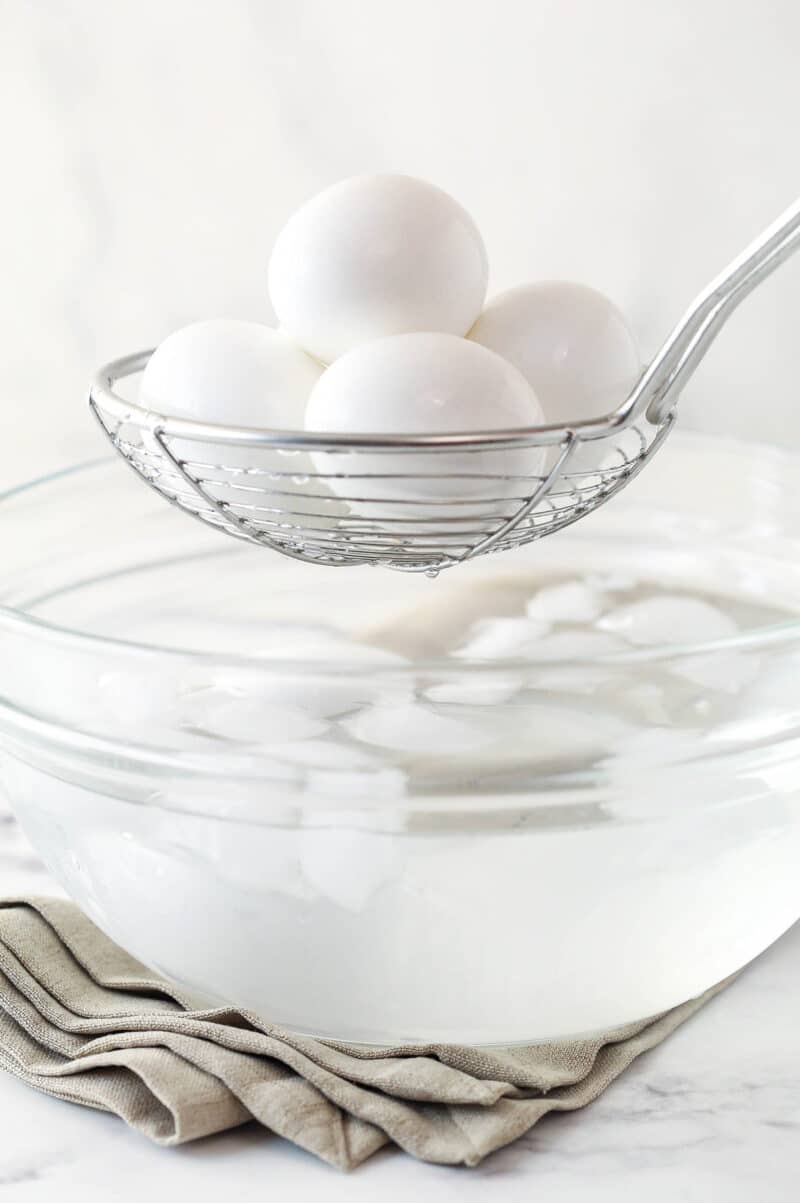 Removing hard boiled eggs from an ice bath.