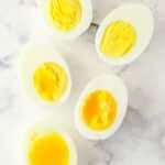 Overhead image of eggs boiled to varying levels of doneness.