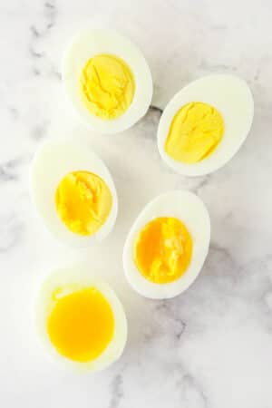 Overhead image of eggs boiled to varying levels of doneness.