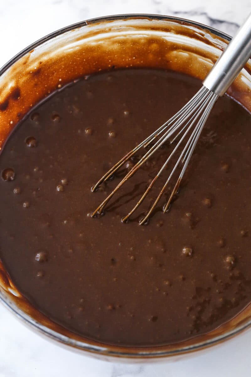 Mixing eggs, buttermilk, and vegetable oil into the dry ingredients for chocolate cake batter.