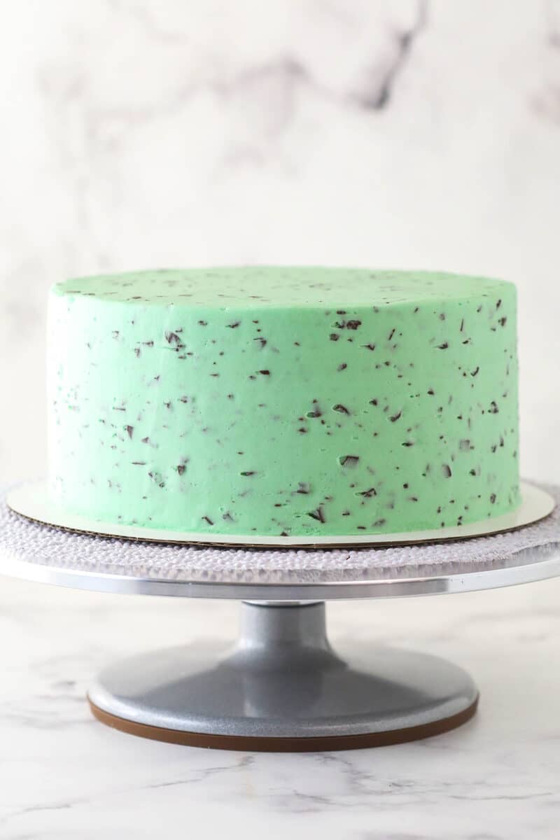 Frosting the outside of mint chocolate cake.