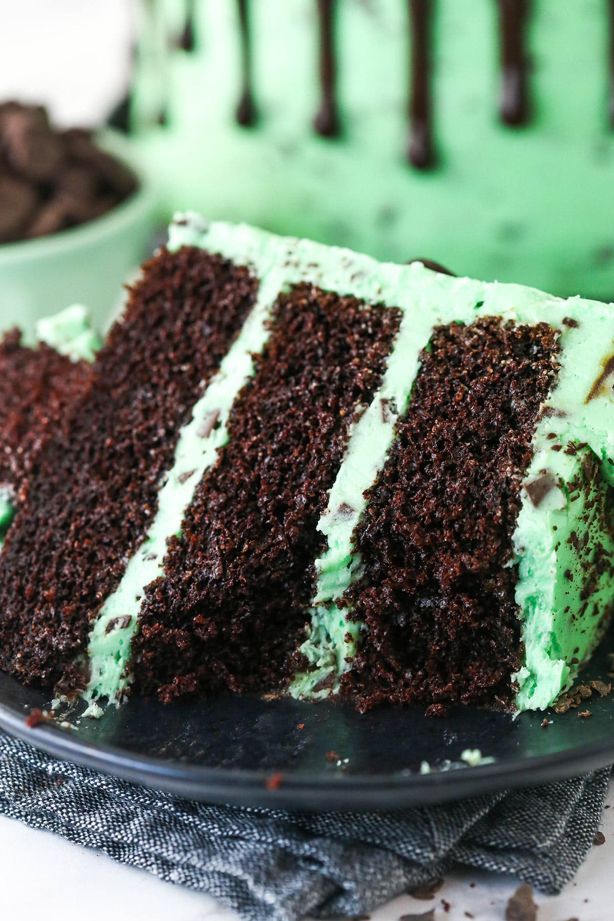 A slice of mint chocolate cake on a plate with a bite taken out of it.
